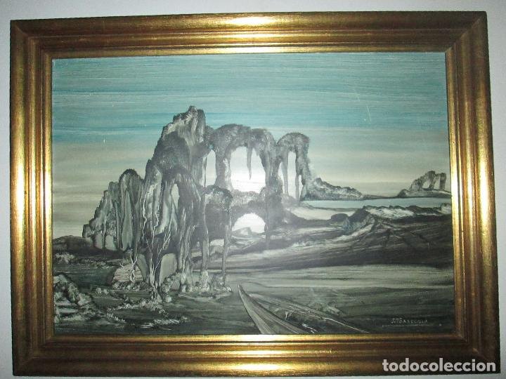 Pintura enmarcada atribuida a J. Torrecilla con un gran arco rocoso sobre una llanura y un camino
